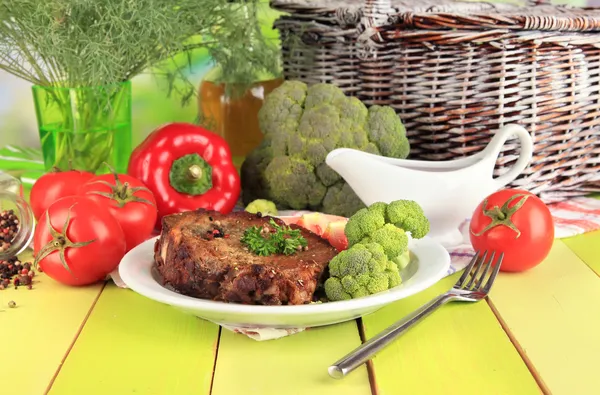 Кусок жареного мяса на тарелке на деревянном столе крупным планом — стоковое фото