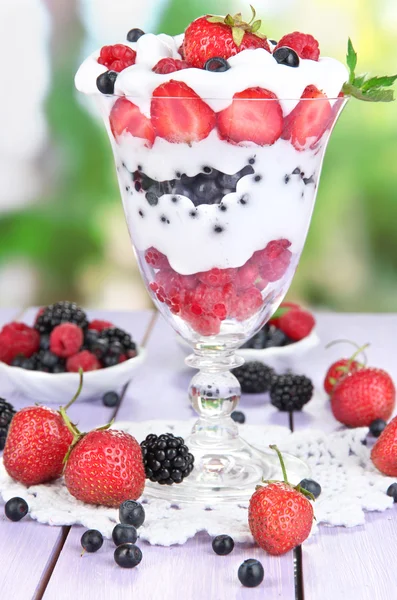 Yogur natural con bayas frescas sobre mesa de madera sobre fondo verde —  Fotos de Stock