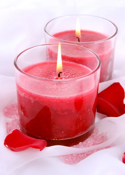 Hermosas velas con flores en tela blanca, de cerca —  Fotos de Stock