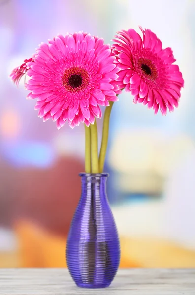 Beautiful pink gerbera flowers in vase on wooden table — Stock Photo, Image
