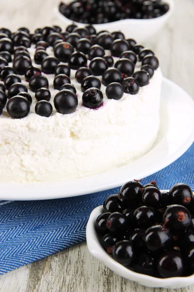 Cheesecake with fresh berries on white plate on wooden table closeup — Stock Photo, Image