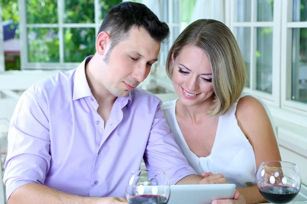 Young couple taking photo with tablet in restaurant — Stock Photo, Image