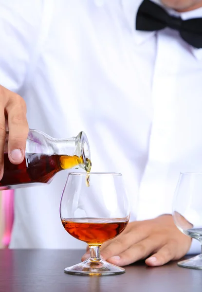 Bartender hälla konjak i glas — Stockfoto