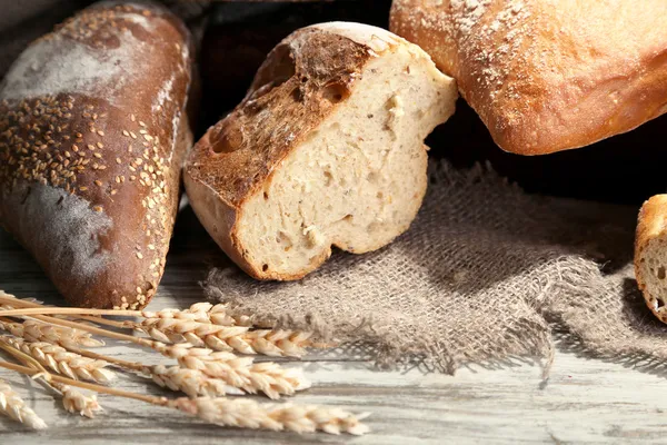 Much bread on sackcloth on wooden board — Stock Photo, Image