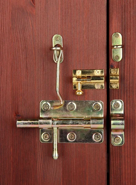 Metal bolts, latches and hooks in wooden door close-up — Stock Photo, Image