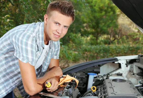 Ung förare reparera bilen motorn utomhus — Stockfoto