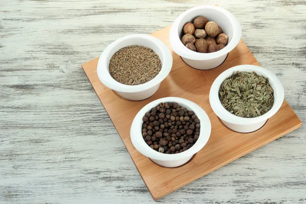 Assortment of spices in white bowls, on wooden background — Stock Photo, Image