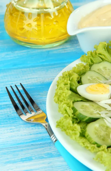 Läcker sallad med ägg, vitkål och gurka på blå bord — Stockfoto