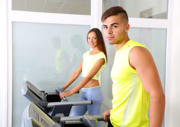 男生和女生在健身房的跑步机上 — 图库照片