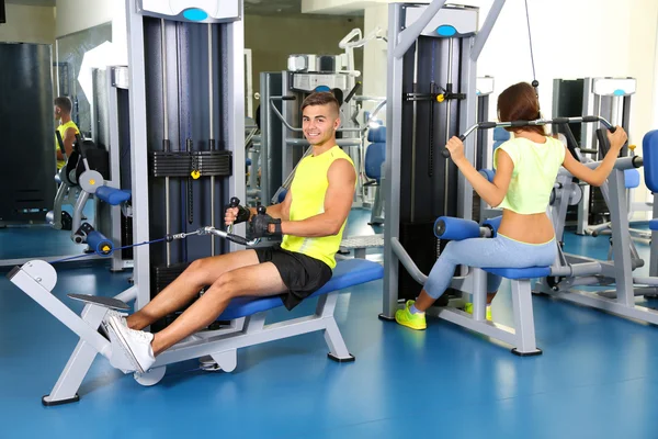 Mann und Mädchen im Simulator im Fitnessstudio — Stockfoto