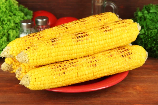 Delicioso maíz dorado a la parrilla en la mesa sobre fondo de madera — Foto de Stock