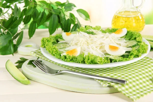 Deliziosa insalata con uova, cavolo e cetrioli sul tavolo di legno — Foto Stock