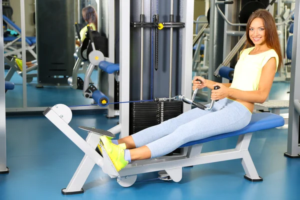 Pretty sporty girl engaged in simulator in gum — Stock Photo, Image