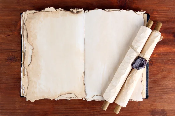 Ouvrir vieux livre et rouleaux sur fond en bois — Photo