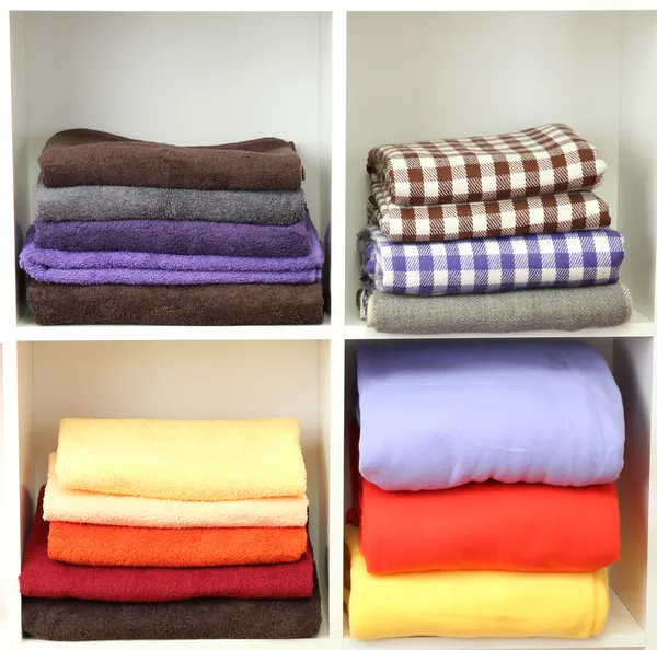 Jasne ręczniki i pledy na półki, na białym tle — Zdjęcie stockowe
