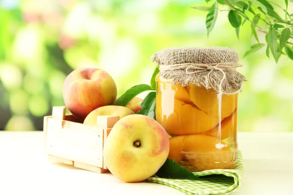 Jar 的罐头桃子和新鲜桃子木桌子上外 — 图库照片