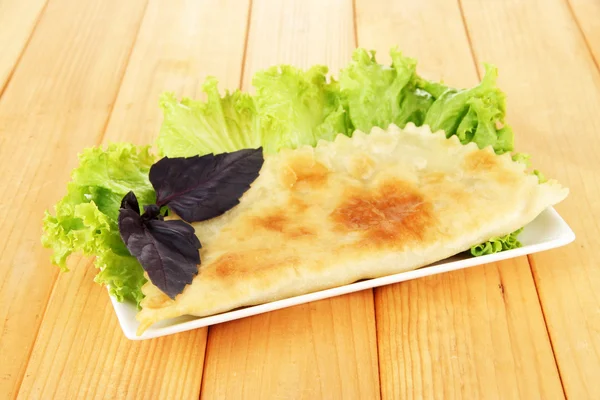 나무 배경 판에 신선한 허브와 함께 맛 있는 cheburek — 스톡 사진