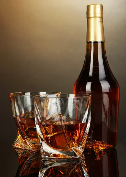 Glass of whiskey with bottle, on dark background — Stock Photo, Image