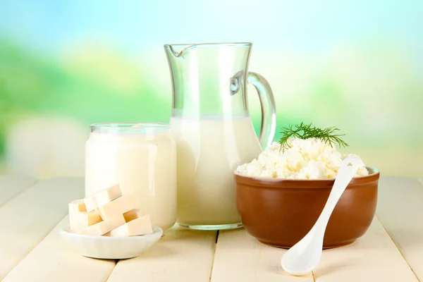 Färska mjölkprodukter på träbord på naturliga bakgrund — Stockfoto