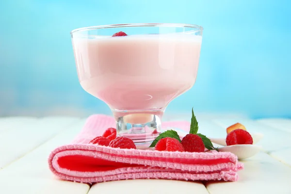 Iogurte delicioso com bagas na mesa em fundo brilhante — Fotografia de Stock