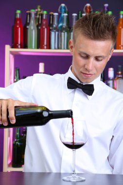 Barmen kırmızı şarap cam içine yağıyor