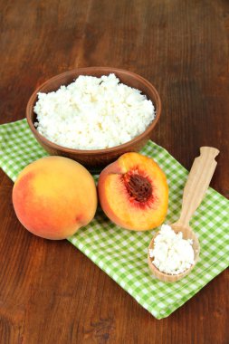 ekşi peynir ve taze şeftali, ahşap masa arka plan üzerinde