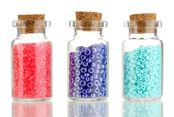 Kleine flessen vol met kleurrijke kralen geïsoleerd op wit — Stockfoto