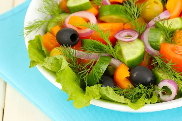 Insalata fresca in piatto su tavolo di legno — Foto Stock