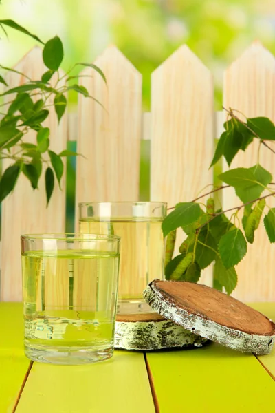 Gläser Birkensaft auf grünem Holztisch — Stockfoto