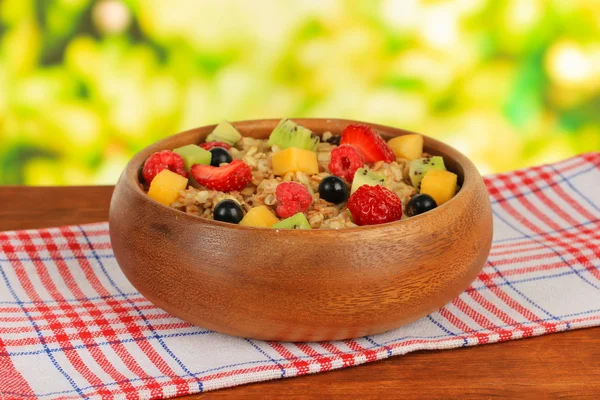 Oatmeal with fruits on table on bright background — Stock Photo, Image