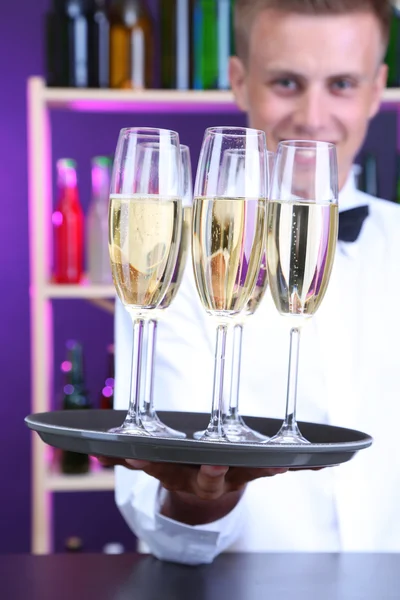 Bartender håller bricka med champagneglas — Stockfoto