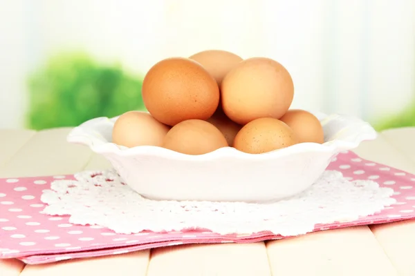 Huevos en plato sobre mesa de madera sobre fondo natural —  Fotos de Stock