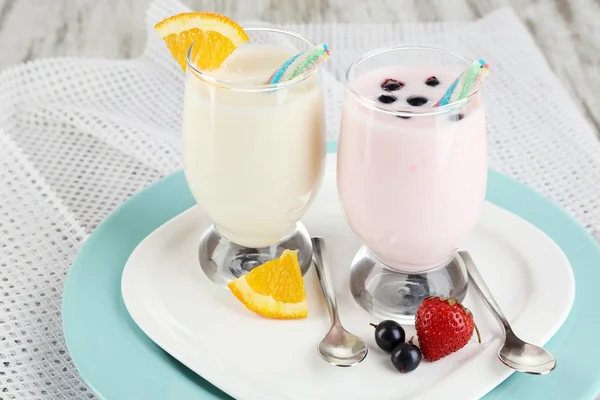 Heerlijke melk schudt met sinaasappel en blackberry op houten tafel close-up — Stockfoto
