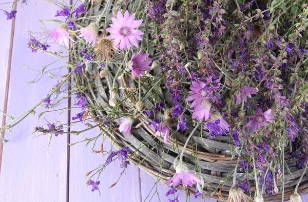 Flores silvestres, sobre estera de mimbre, sobre fondo de madera de color —  Fotos de Stock