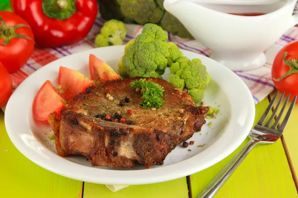 Stekt köttbit på plattan på träbord närbild — Stockfoto