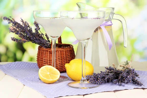 薰衣草柠檬水在玻璃壶和鸡尾酒的眼镜，在明亮的背景上 — 图库照片