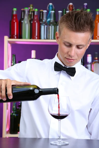 Barman está derramando vinho tinto em vidro — Fotografia de Stock