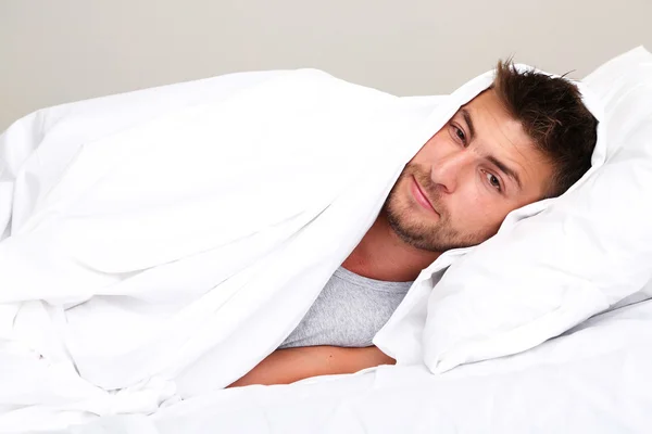 Handsome young man in bed — Stock Photo, Image