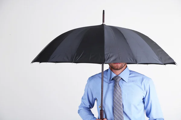 Empresario con paraguas. sobre fondo gris —  Fotos de Stock