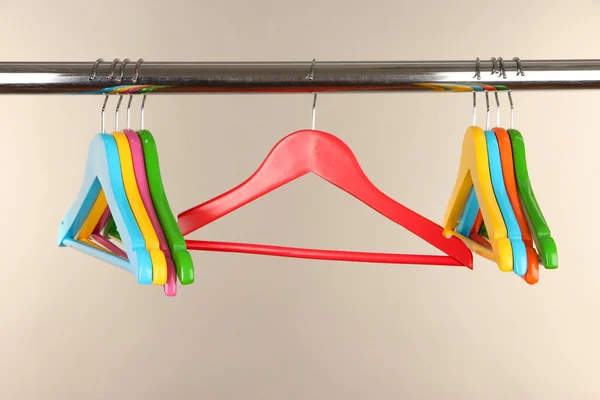 Cabides de roupas coloridas no fundo cinza — Fotografia de Stock
