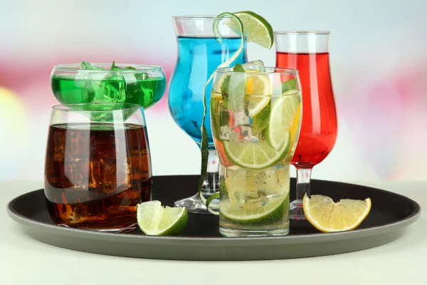 Many glasses of cocktails on tray on table, on bright background — Stock Photo, Image