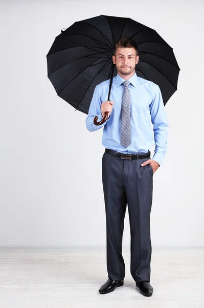 Geschäftsmann mit Regenschirm. auf grauem Hintergrund — Stockfoto