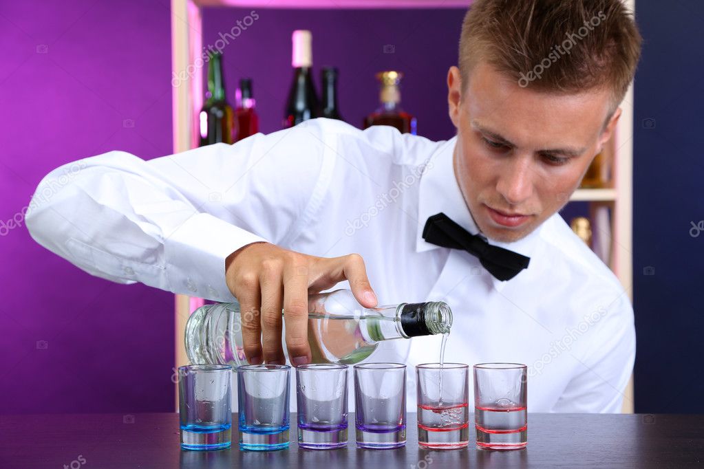 Bartender is pouring vodka into glasses