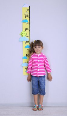 küçük kız odada duvara yükseklik ölçme