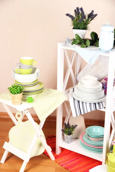 Mobília branca bonita com utensílios de mesa e decoração, no fundo da parede de cor — Fotografia de Stock