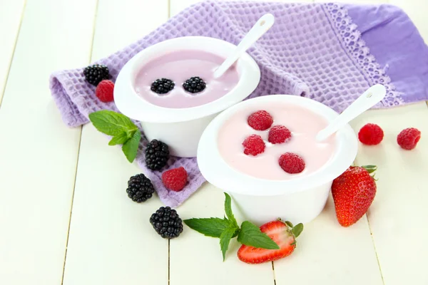 Вкусный йогурт с ягодами на столе крупным планом — стоковое фото