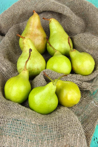 Pears on cutting board, on sackcloth background — Stock Photo, Image