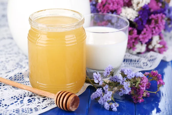 Honing en melk op blauwe houten tafel close-up — Stockfoto