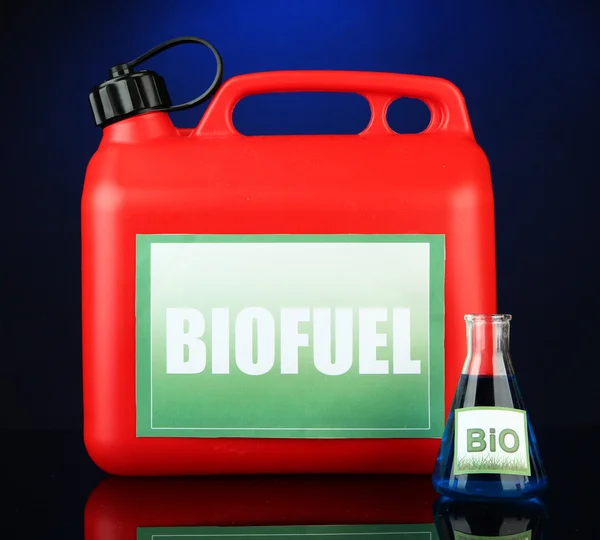 生物燃料罐和蓝色背景上的小瓶 — 图库照片