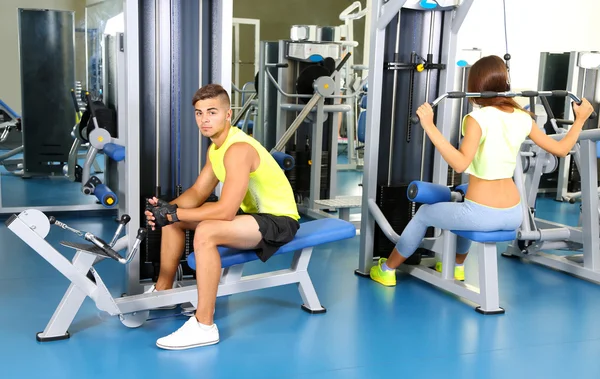 男生和女生从事模拟器在健身房 — 图库照片